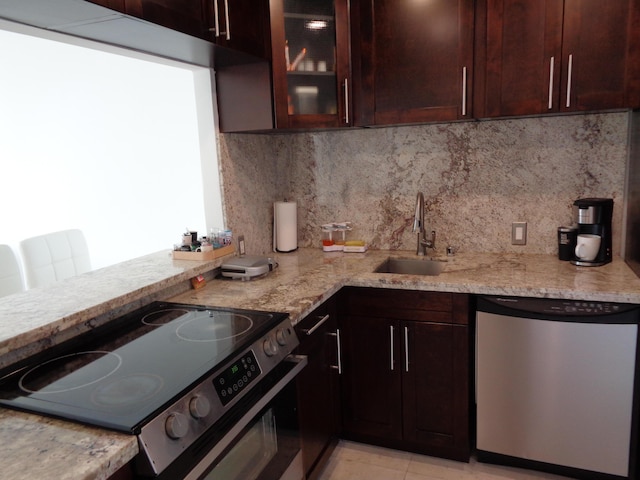 kitchen featuring light stone countertops, sink, appliances with stainless steel finishes, and tasteful backsplash