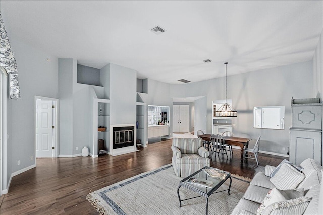 living room with a high ceiling and dark hardwood / wood-style floors