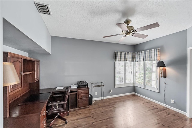 office area with ceiling fan, dark hardwood / wood-style flooring, and a textured ceiling