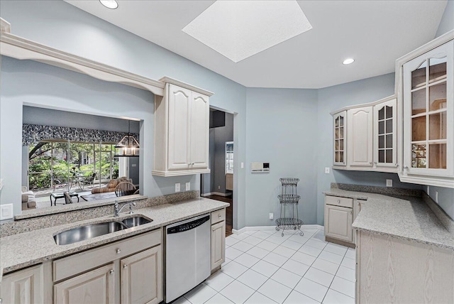 kitchen with light stone countertops, stainless steel dishwasher, sink, light tile patterned floors, and a chandelier