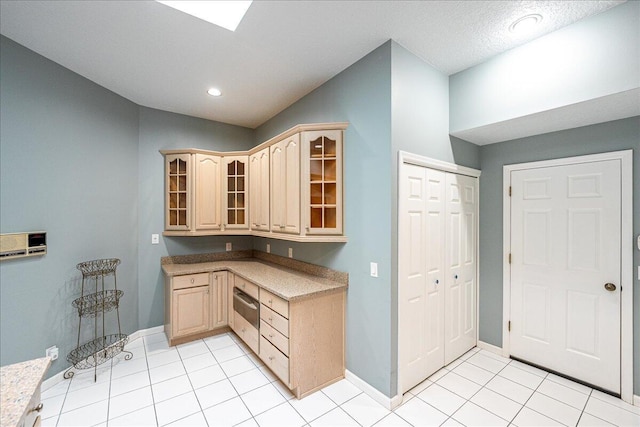 kitchen featuring light tile patterned floors and light brown cabinetry