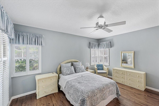 bedroom with a textured ceiling, ceiling fan, and dark hardwood / wood-style floors