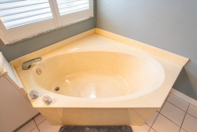 bathroom with tile patterned flooring and a bath