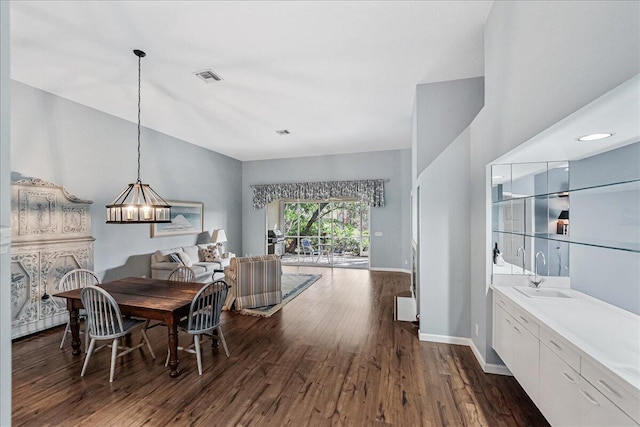 dining space with dark hardwood / wood-style floors, sink, and a chandelier