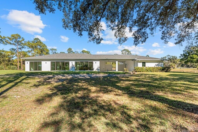 rear view of property with a yard