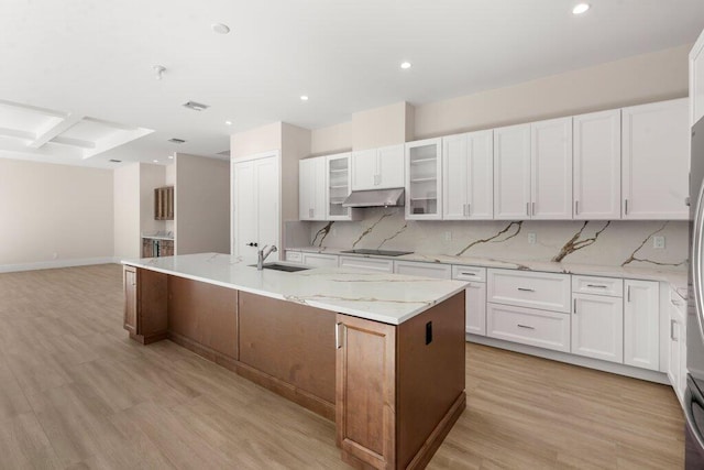 kitchen featuring sink, white cabinetry, black electric stovetop, and a kitchen island with sink