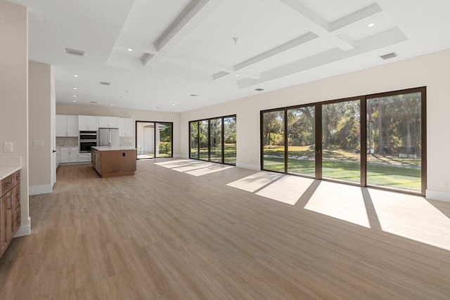 unfurnished living room featuring light wood-type flooring, coffered ceiling, and beamed ceiling