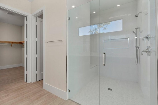 bathroom featuring wood-type flooring and walk in shower