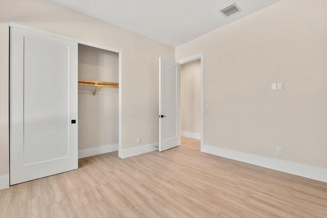 unfurnished bedroom with a closet and light hardwood / wood-style floors