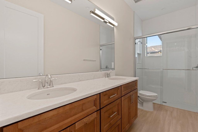 bathroom featuring toilet, walk in shower, hardwood / wood-style floors, and vanity