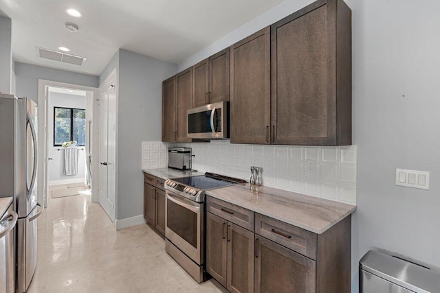 kitchen featuring backsplash, appliances with stainless steel finishes, and dark brown cabinets