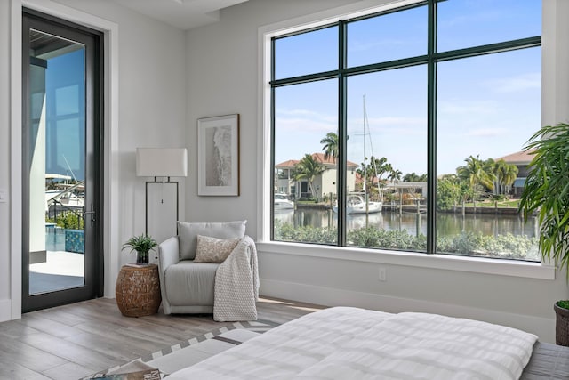 bedroom featuring light hardwood / wood-style floors and a water view