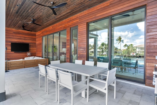 view of patio / terrace featuring ceiling fan, outdoor lounge area, and a water view