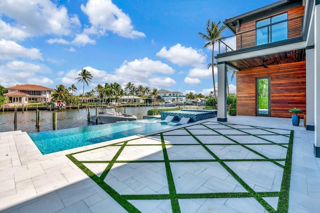 view of swimming pool with an in ground hot tub, a water view, and a patio