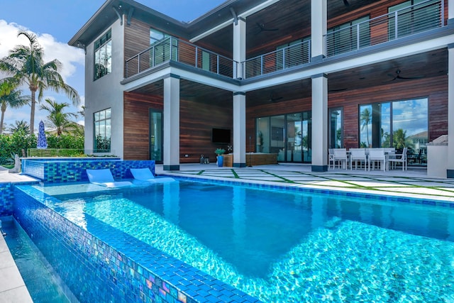 view of swimming pool with ceiling fan and a patio area