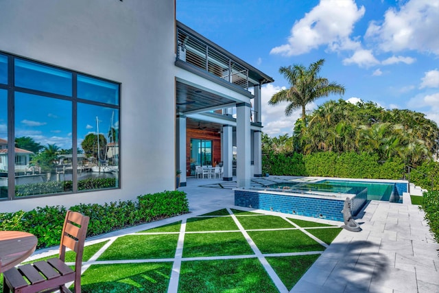 view of pool with ceiling fan, an in ground hot tub, a yard, a water view, and a patio