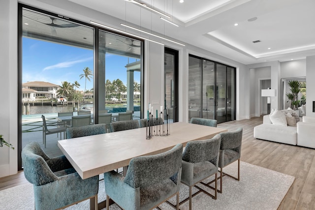 dining space featuring a water view and light wood-type flooring