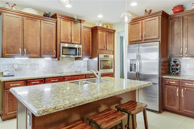 kitchen featuring a center island with sink, sink, and appliances with stainless steel finishes