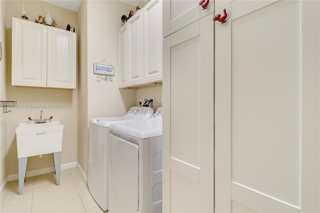 clothes washing area with cabinets, sink, light tile patterned floors, and washer and dryer