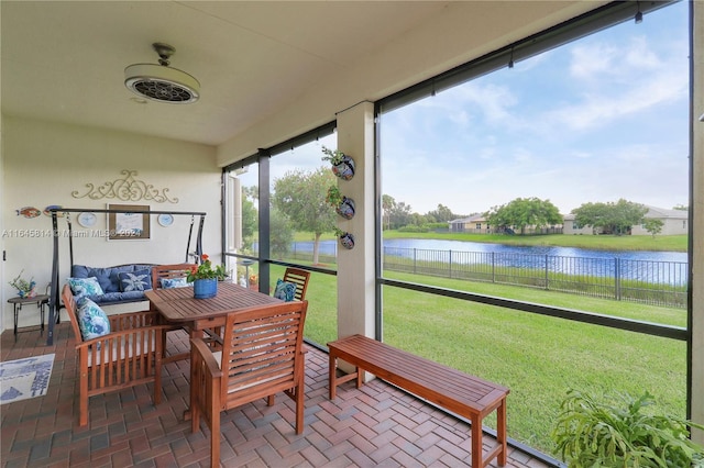 sunroom featuring a water view