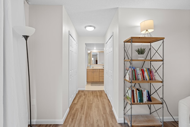 corridor featuring hardwood / wood-style flooring and a textured ceiling