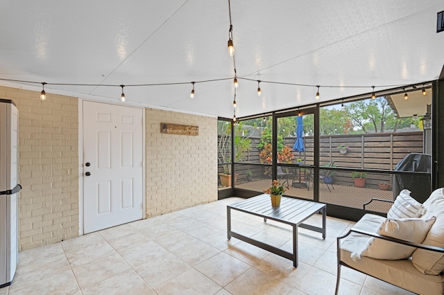 living room featuring brick wall and light tile patterned floors