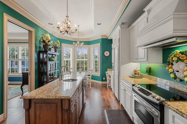 kitchen featuring white cabinetry, hanging light fixtures, electric stove, a kitchen island with sink, and custom exhaust hood