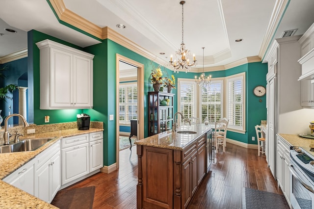 kitchen with white cabinets, decorative light fixtures, stainless steel range with electric stovetop, and sink