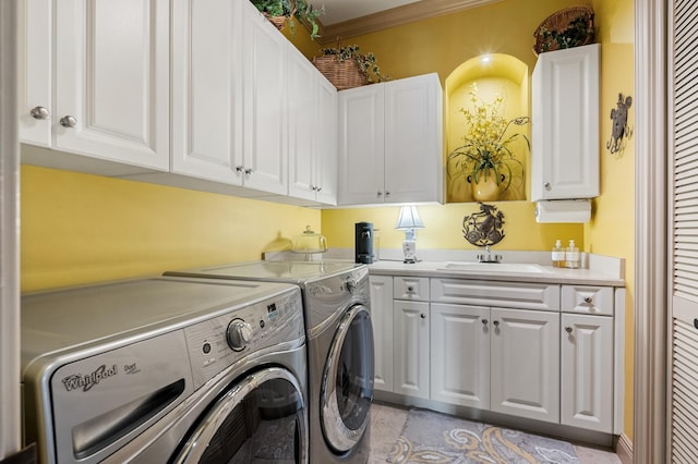 clothes washing area with crown molding, cabinets, separate washer and dryer, and sink