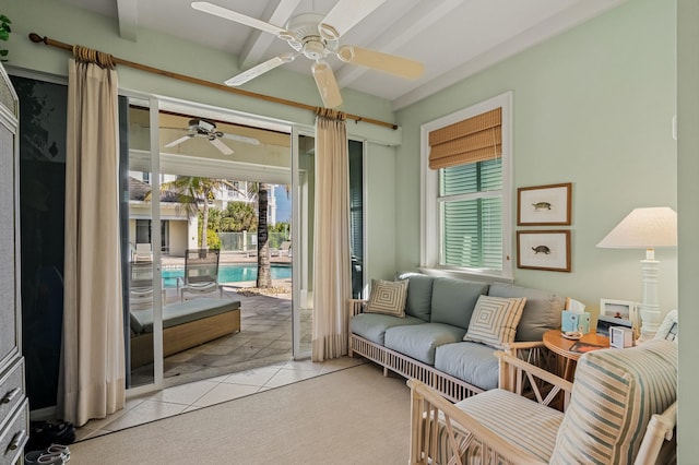 living room featuring ceiling fan, beam ceiling, light tile patterned floors, and a wealth of natural light