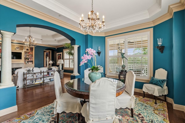 dining area featuring a notable chandelier, decorative columns, ornamental molding, and a tray ceiling