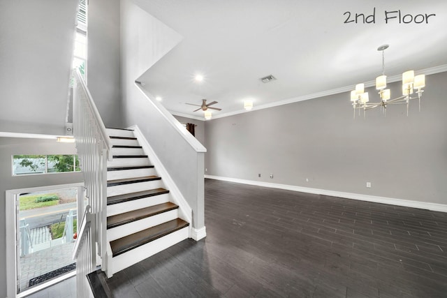 stairs featuring ornamental molding, ceiling fan with notable chandelier, and hardwood / wood-style flooring