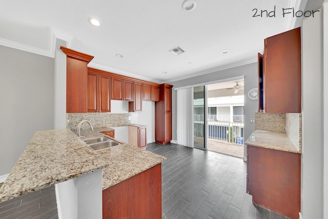 kitchen with kitchen peninsula, a breakfast bar area, backsplash, crown molding, and sink