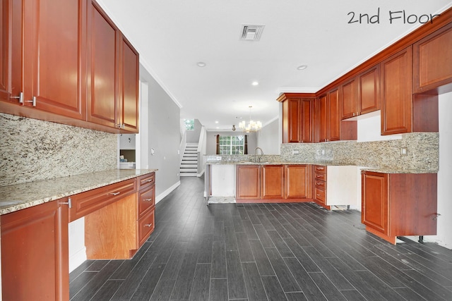 kitchen featuring decorative light fixtures, sink, light stone counters, and decorative backsplash