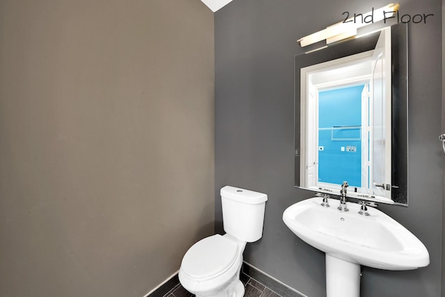 bathroom featuring toilet, sink, and tile patterned floors