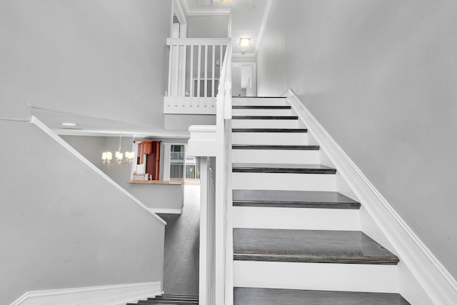 stairs with an inviting chandelier and hardwood / wood-style flooring