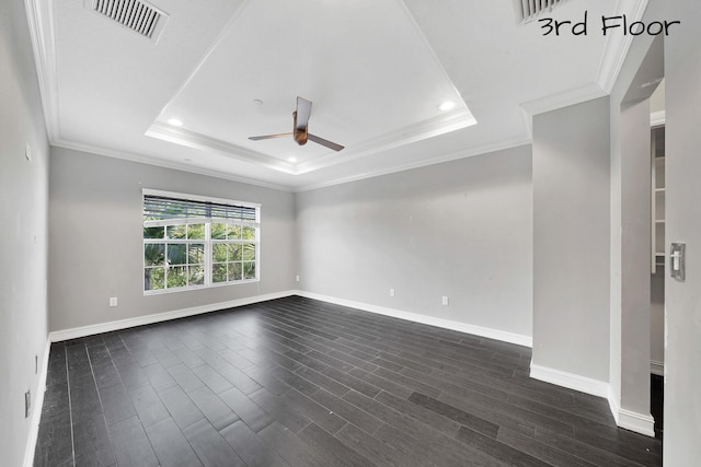 unfurnished room with a raised ceiling, ceiling fan, dark wood-type flooring, and crown molding