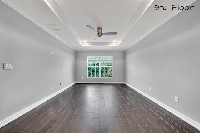 empty room featuring dark wood-type flooring, ceiling fan, crown molding, and a raised ceiling