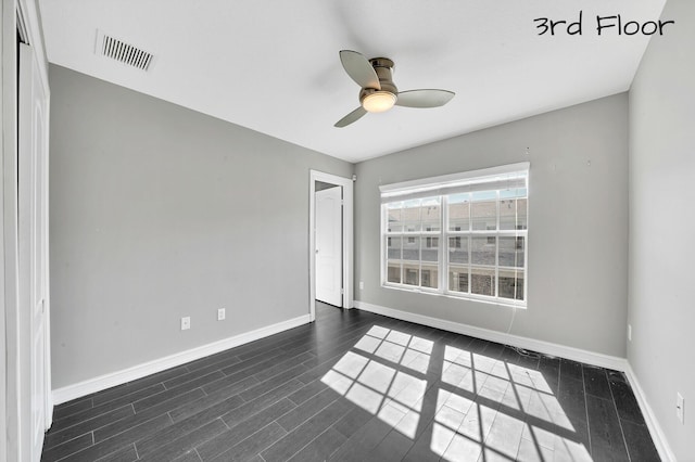 empty room featuring ceiling fan and dark hardwood / wood-style floors