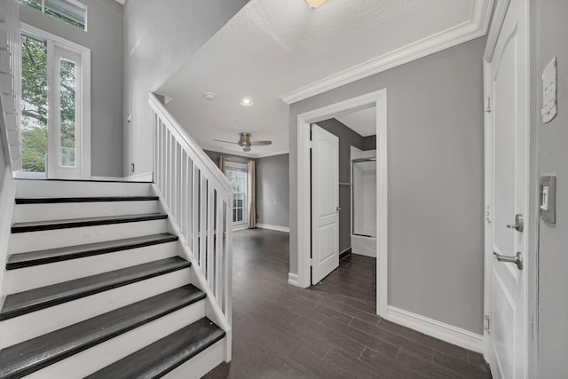 staircase with ceiling fan, crown molding, a textured ceiling, and hardwood / wood-style flooring