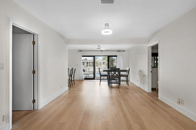 dining area featuring light wood finished floors, a ceiling fan, visible vents, and baseboards