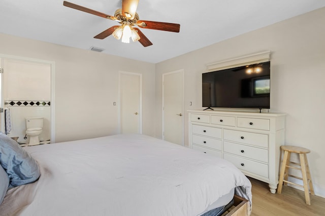 bedroom featuring ceiling fan, ensuite bath, and light hardwood / wood-style flooring