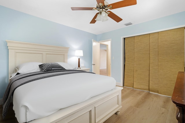 bedroom featuring ceiling fan, a closet, and light hardwood / wood-style floors