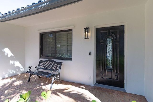 doorway to property featuring stucco siding