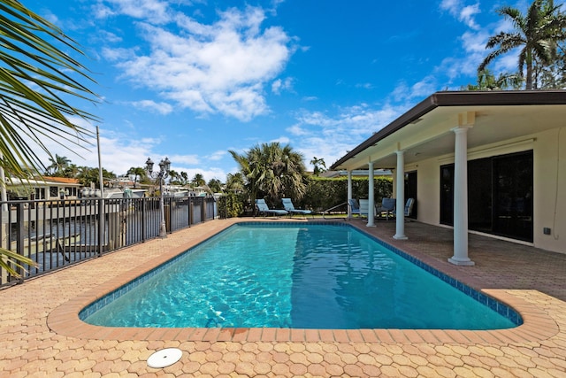 view of swimming pool featuring a water view and a patio