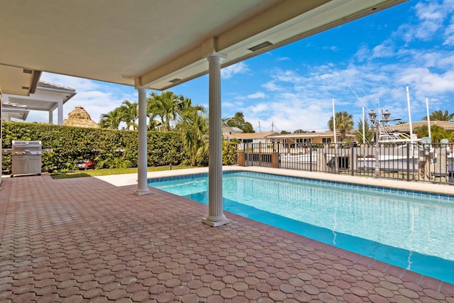 view of swimming pool featuring a grill and a patio