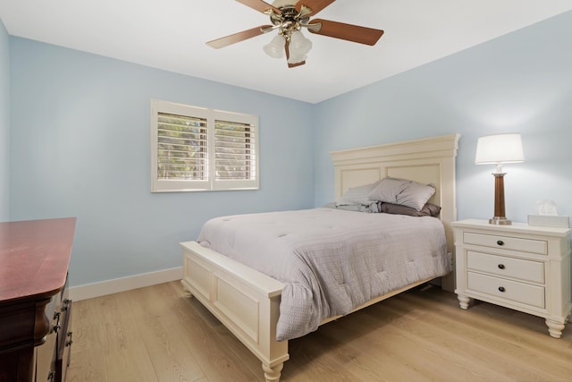 bedroom featuring a ceiling fan, baseboards, and light wood finished floors