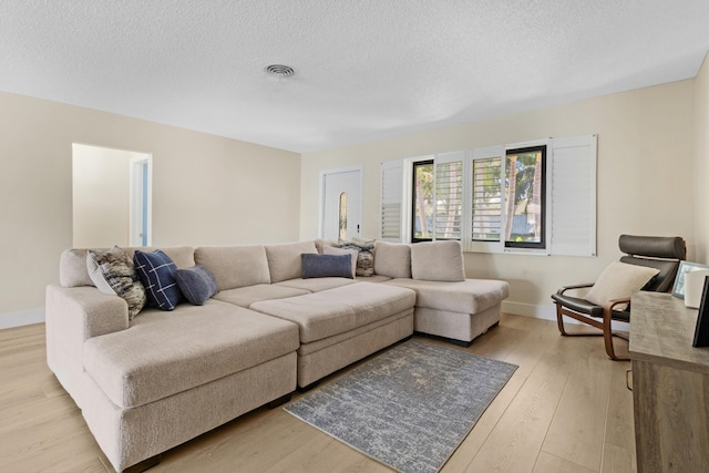 living room with a textured ceiling and light hardwood / wood-style flooring