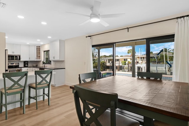 dining area with light hardwood / wood-style floors, sink, and ceiling fan