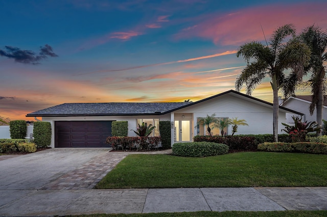 view of front of property featuring a garage and a yard